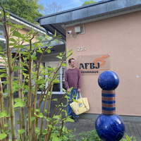 "Thilo steht mit der Einkaufstasche vor dem AFBJ-Wohnhaus"